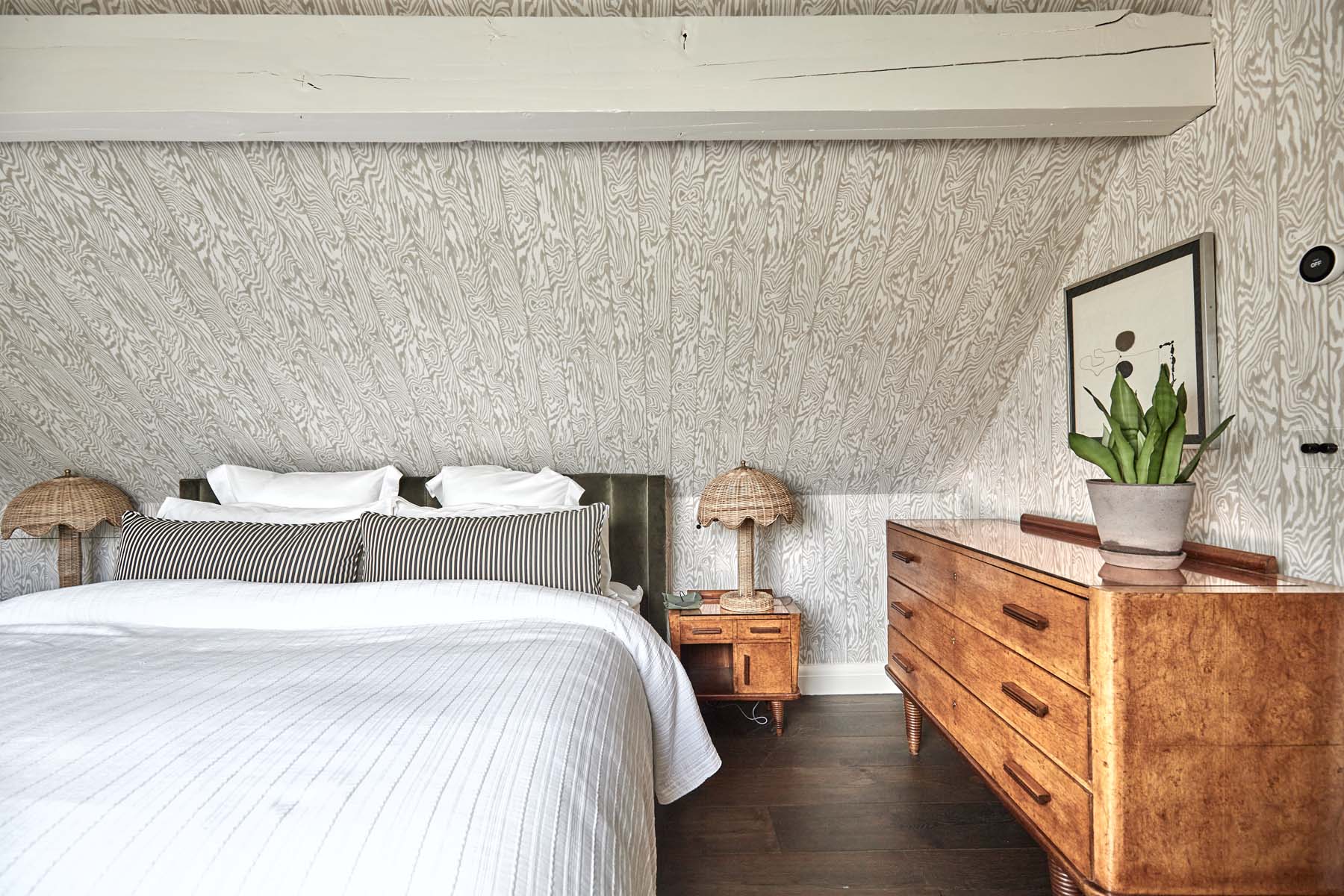 bedroom with sloping loft ceiling and rattan bedside lamps