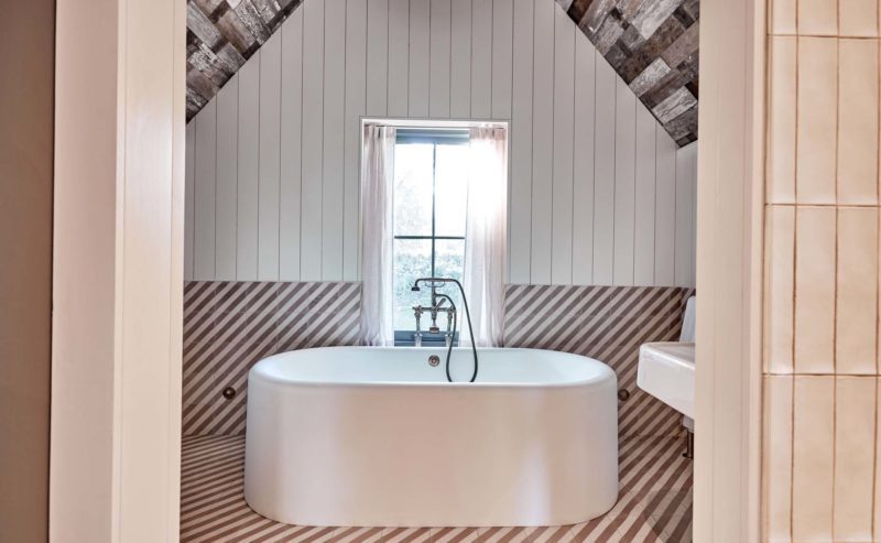 Large standalone bathtub with vaulted bathroom ceiling