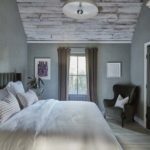 Bed in bedroom with armchair and window