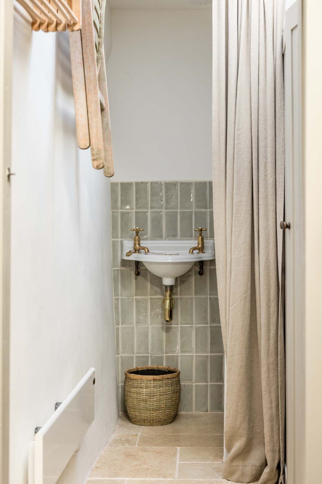 bathroom sink with green tiles and curtain