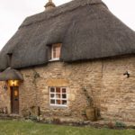 Thatched cottage with honey coloured stone