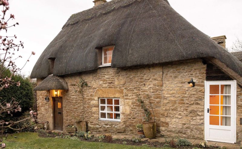 Thatched cottage with honey coloured stone