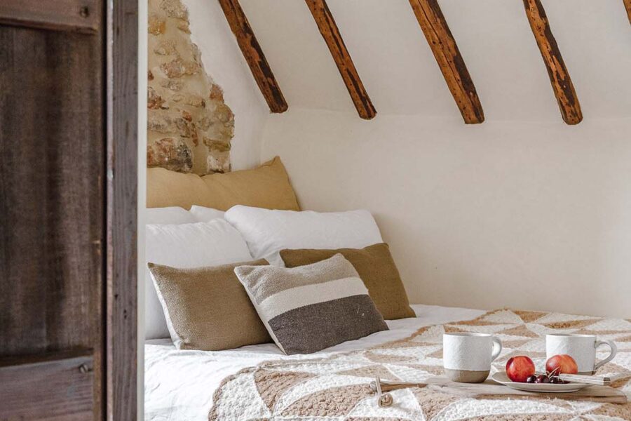 Cottage bedroom exposed beams and a patchwork quilt