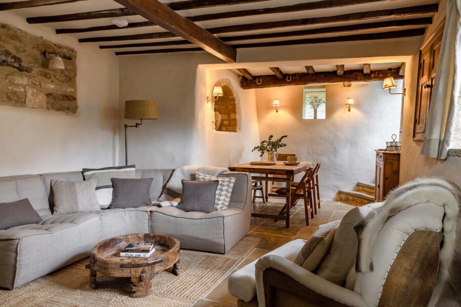 Cosy cottage living and dining room with exposed beams and rustic modern furnishings