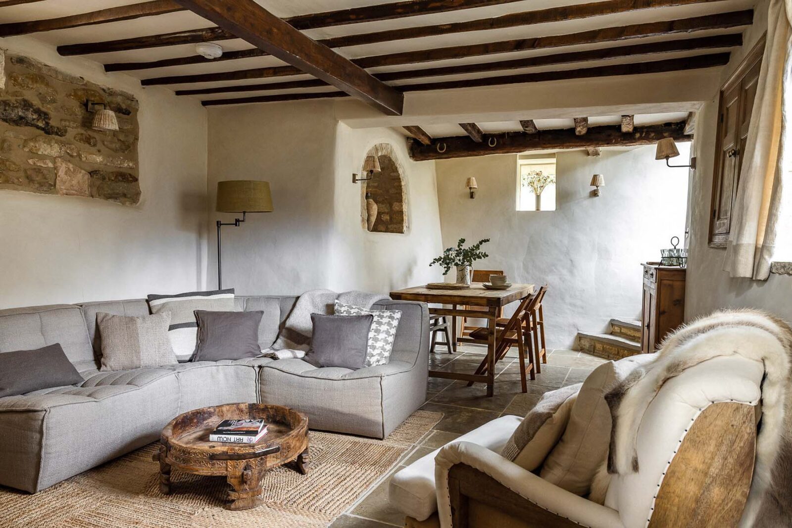 Cosy cottage living and dining room with exposed beams and rustic modern furnishings