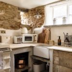 Corner of a quaint cottage kitchen with exposed stone walls