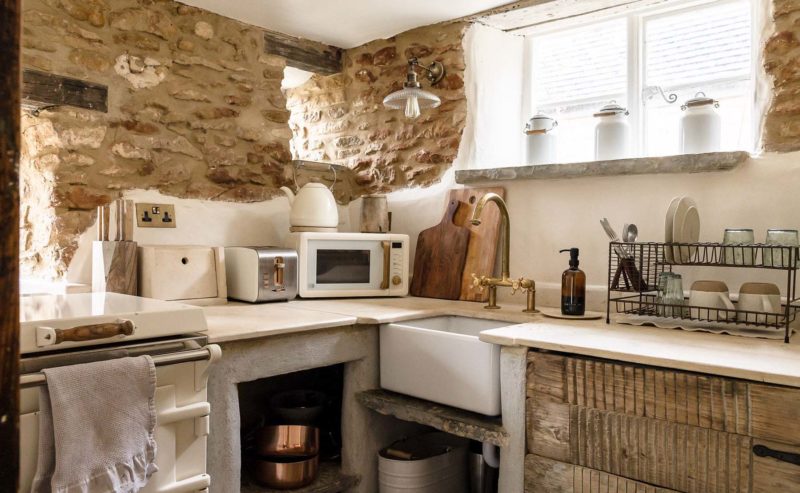 Corner of a quaint cottage kitchen with exposed stone walls