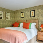 double bedroom with decorative green flower wallpaper