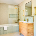 bathroom with bathtub and sage green tiles