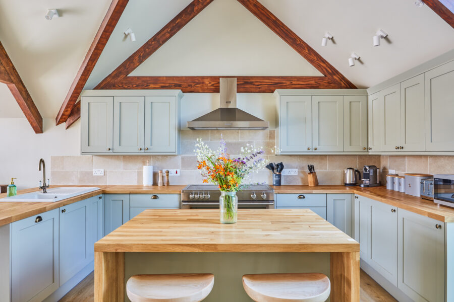 kitchen with sage green cabinets and central island
