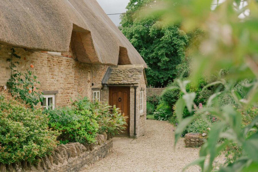 thatched cottage surrounded by greenery