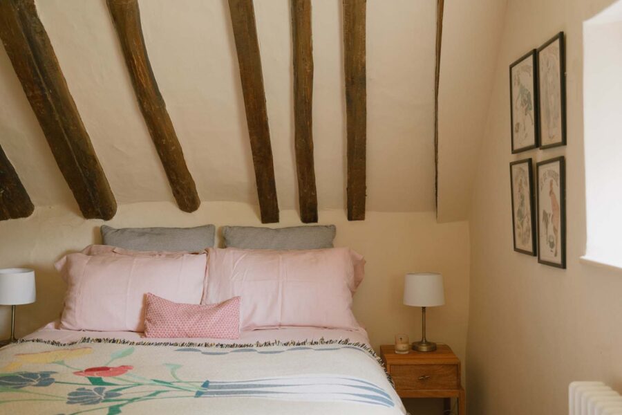 bed with pink pillows and overhead beams