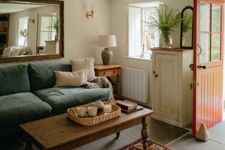 corner of a cosy living room with blue sofa and rattan tray with tea for two on a coffee table