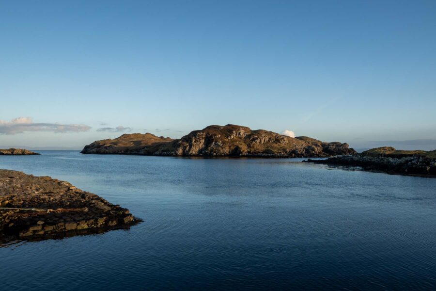 beautiful still sea surrounding a rocky island on a sunny clear sky day